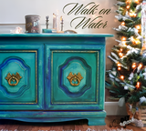Cabinet painted in DIY Paint Co. Walk on Water, teal and gold hues, positioned beside a lit tree.