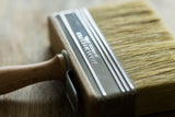 Staalmeester Wall Brush Series 3005 with wooden handle, shown resting on a wooden surface.