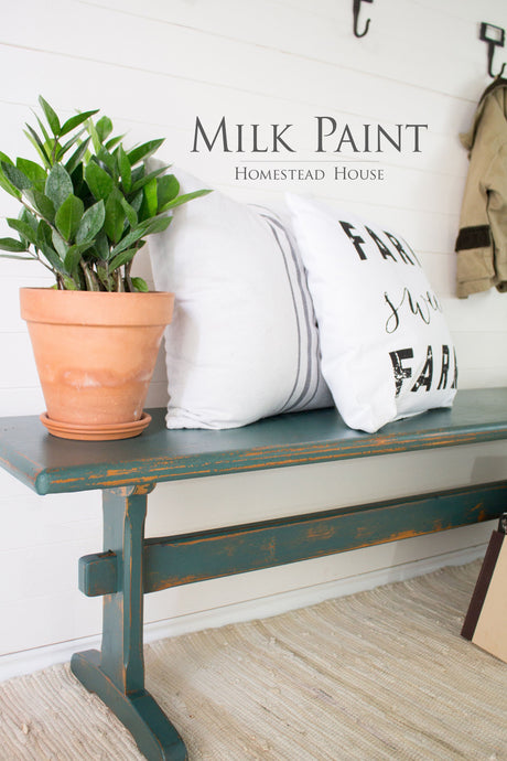 Waterloo Green Homestead House bench with potted plant, white pillows, and “Milk Paint” text above.