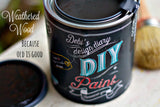 Open can of DIY Paint Co. Weathered Wood paint with lid and paintbrush on table.