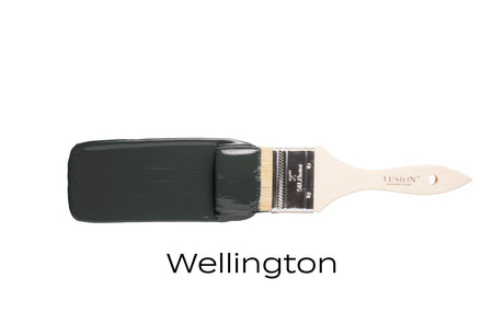 Paintbrush with Fusion Mineral Paint Wellington dark green-grey on bristles.