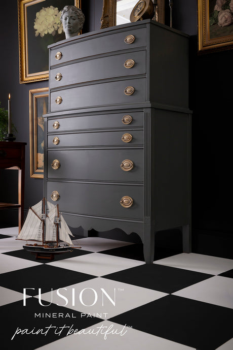 Tall gray Wellington Fusion Mineral Paint dresser with gold handles, sailboat model, and bust on top.