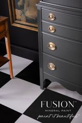 Black dresser with gold handles, painted Wellington Fusion Mineral Paint, on a checkered floor.