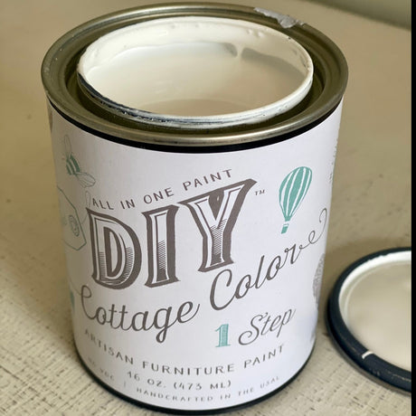 Open can of DIY Paint Co. White Linen DIY Cottage Color with lid beside it on a flat surface.