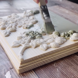 Hand painting green on raised Wild Berries Mould by I.O.D. for spring-themed wood panel accents.