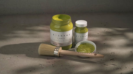 Three Willow Alchemy Paint jars by Fusion Mineral Paint with a paintbrush on a gray surface.