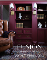 Brown leather chair beside shelves painted in Winchester by Fusion Mineral Paint, with books and brass decor.