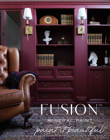 Brown leather chair beside shelves painted in Winchester by Fusion Mineral Paint, with books and brass decor.