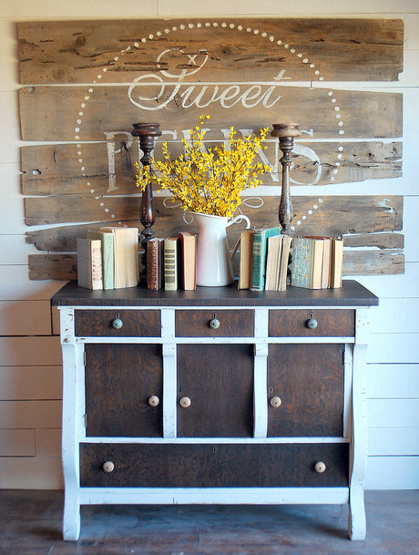 Wooden dresser finished in Window Pane by Old Fashioned Milk Paint, topped with books, yellow flowers, and candle holders.