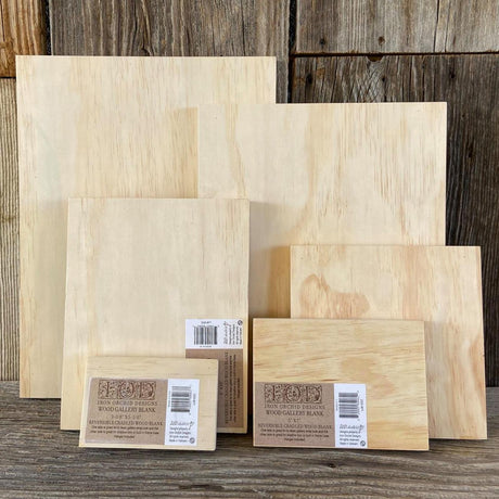 Seven I.O.D. Wood Gallery Blanks by Iron Orchid Designs displayed upright on a wood surface.