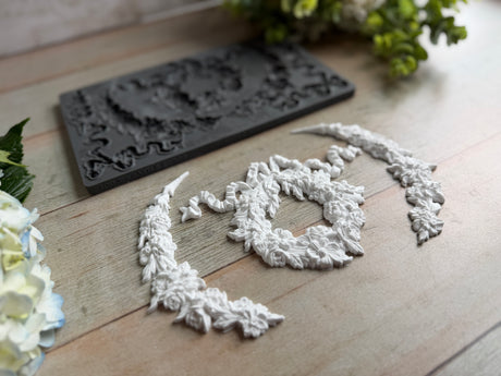IOD Wreath & Swags Mould and white floral decor displayed on wood surface.