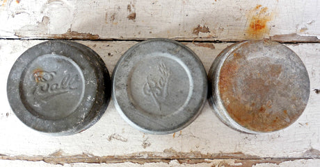 Three Ball-logo jar lids; one shows rust, all on wood background with Old Fashioned Milk Paint Zinc finish.