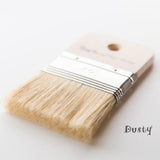 The Dusty Paintbrush by Paint Pixie with light bristles and wood handle marked 70 placed near the word Dusty.