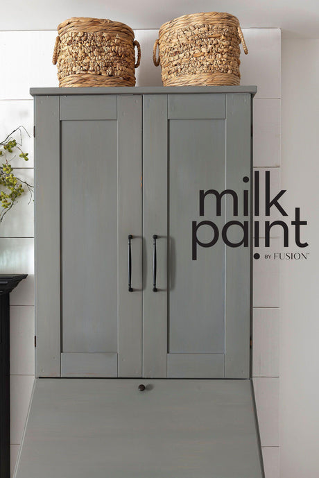 Gray cabinet with black handles, two baskets on top, and Gotham Grey Fusion Mineral Paint on the doors.