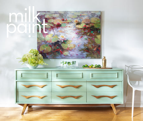Dresser painted with Fusion’s Mojito Milk Paint, shown with gold accents and floral art on a white wall.