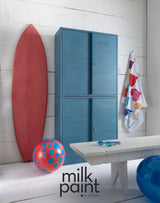 Blue locker, red surfboard, and polka-dot ball finished with Fusion Poolside Milk Paint in sunlight.