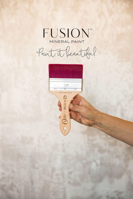 Hand holding a Staalmeester Spalter Flat Blending Ultimate ONE Brush with Fusion Mineral Paint text visible.