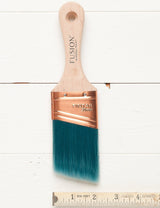 Fusion Mineral Paint 2″ Synthetic Angled Workshop Brush with teal bristles, shown beside a ruler.